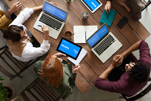 a group of people sitting at a table with a laptop