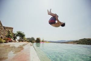 boy doing backflip into pool