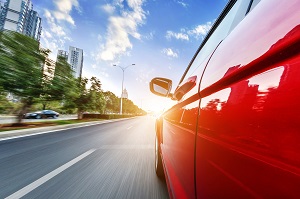 red car driving on road