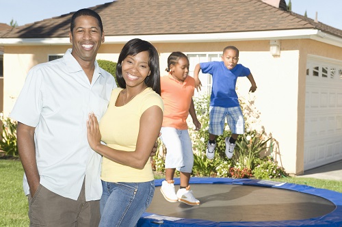 family of 4 standing outside home